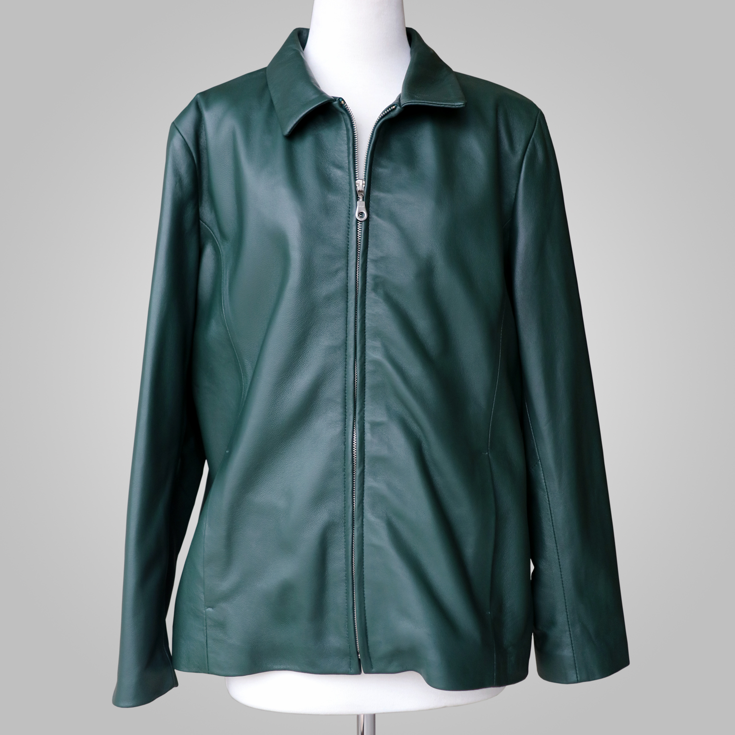 Women’s green leather jacket with collar and front zip on a mannequin