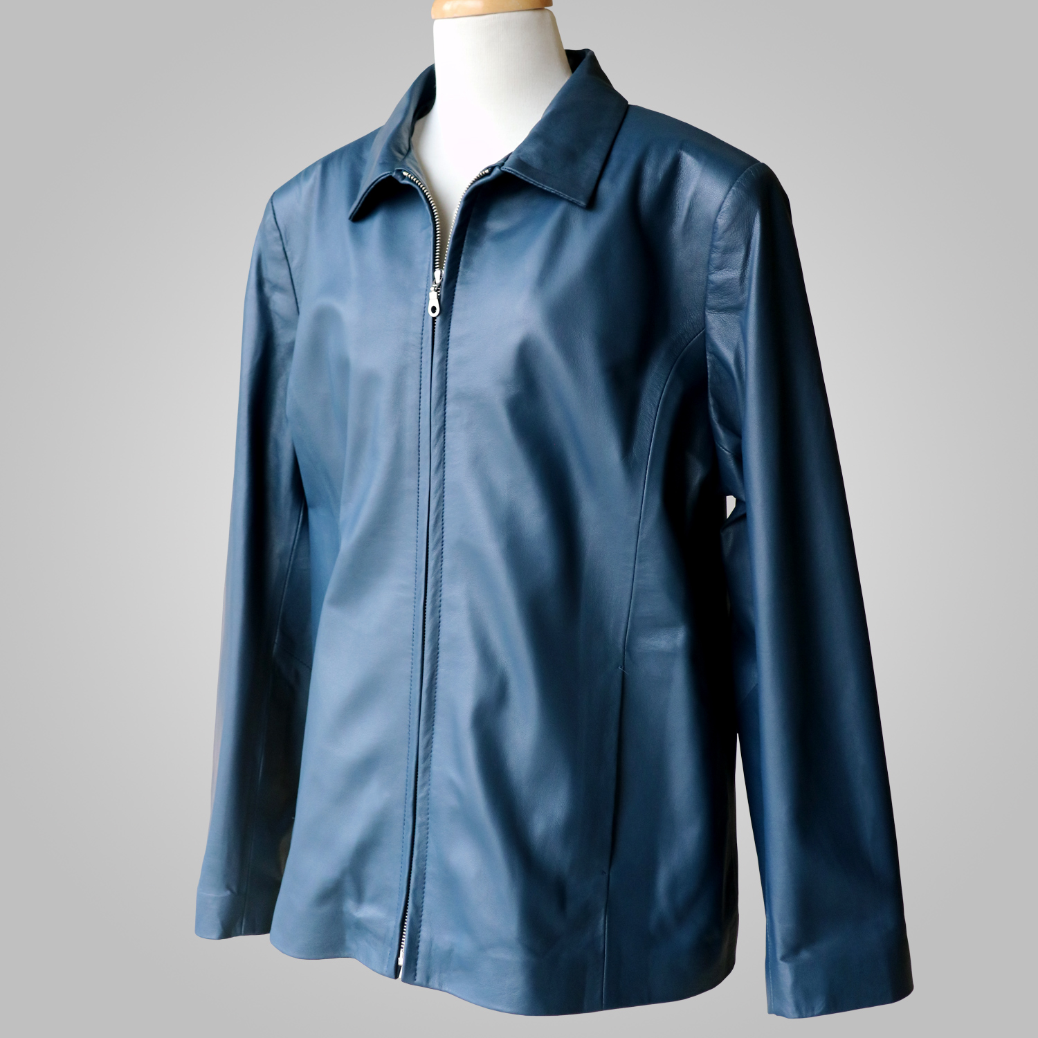 Women’s navy leather jacket at an angled front view on a mannequin